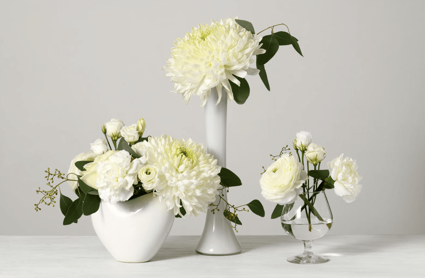 White flowers in vases with varying heights.png